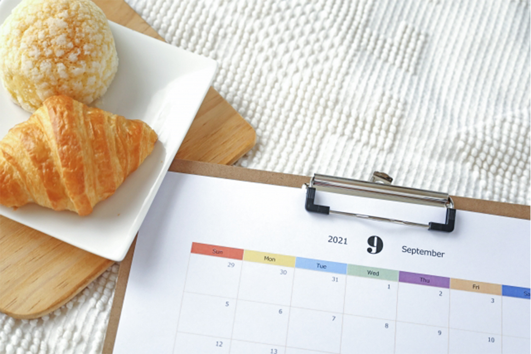 2種類のパンが乗った皿とバインダーに挟まれた9月のカレンダー